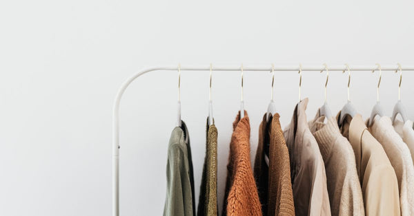 A minimalist clothing rack displaying neutral-toned outfits in an organized indoor setting. Photo by www.kaboompics.com on Pexels.