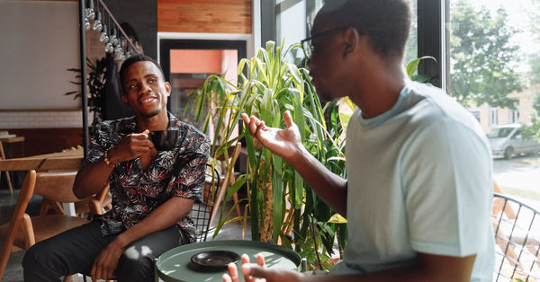 Two friends having a lively conversation over coffee in a cozy coffee shop setting. Photo by Thirdman on Pexels.